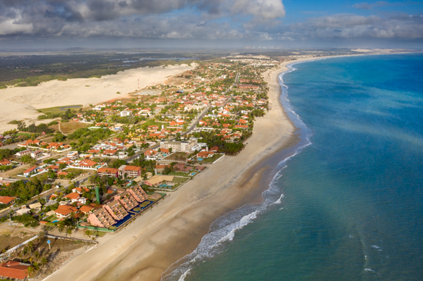 Cumbuco beach with kites in the sky and dunes behind
